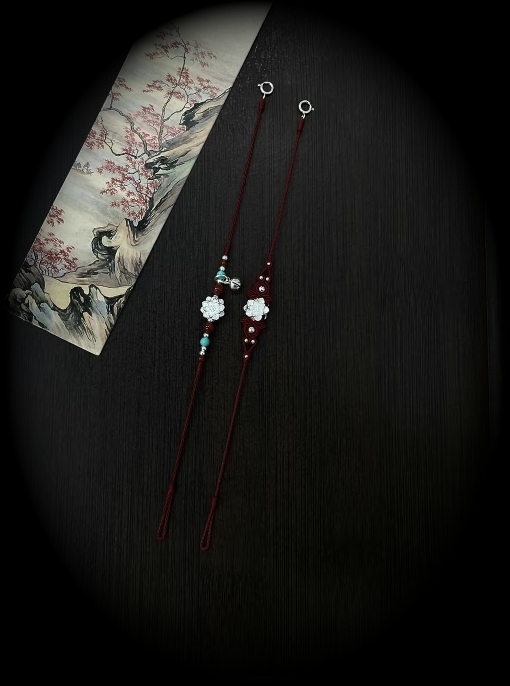 A hand-tied dark cord bracelet with a red thread detail